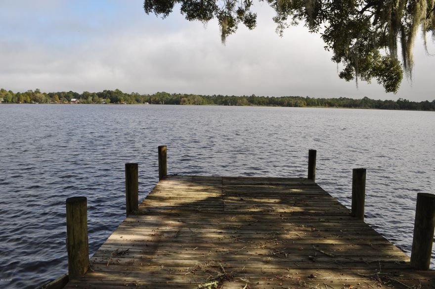 Waterfront home on Deerpoint Lake with a boat dock, seawall and a gorgeous view!  The interior of this 3BR/2BA home features an open floor design, perfect for enjoying the scenery.  The living room includes a cathedral ceiling and wood burning fireplace.  There are two large pantries in the eat-in kitchen and all appliances convey.  Not only is there a very spacious Florida room along the back of the home, there is also a glassed-in Sunroom with door walls that open for a wonderful cross breeze off the lake.     Additional features include a Culligan Filtration System, Bahama shutters and a metal roof with a lifetime warranty.  Parking is abundant thanks to an attached carport and a detached two car garage/workshop.  There is a public boat ramp and park not five minutes from the home. This is an excellent property for "getting away from it all" and yet, you're only 10 minutes from town.  All info is approx. and must be verified by Buyers if important.