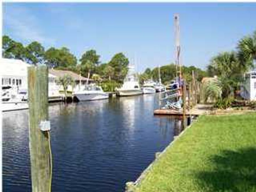 This Bay Point canal home is located ''east of the bridge'' which means there are no structures to go under between this home and the Gulf. The roof was replaced after the hurricane. The wooden sea wall has been replaced with a vinyl sea wall.  Redfish is a quiet street off the main roads with very little traffic. The lot features 94' on the canal which will accommodate several water crafts. Bay Point has a championship golf course, several restaurants, clay tennis courts, 24 hour roving security, a new marina (currently under construction) and a Sheraton resort hotel. This home is perfect for someone with a large yacht!