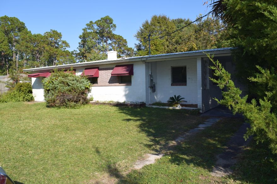 Great location in Lynn Haven--across the street from Kinsual Park and near the Bay. This huge lot is all fenced, has a carport  plus a sizable workshop with additional covered  parking. The house has great bones and offers amazing potential at an affordable price! The home is tiled throughout, has a living room, a Florida room, two bedrooms and one bath.