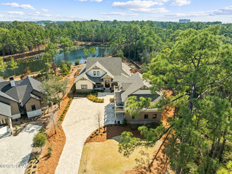 Welcome to 1400 Otter Point, a rare opportunity to own one of the most exceptional properties in the prestigious, gated Wild Heron community—nestled along the shores of Florida's largest coastal dune lake, Lake Powell. This luxurious coastal craftsman estate sits on an oversized, private lot with serene pond views, blending refined design with resort-style living.

Step inside to find a custom-designed kitchen that will impress even the most discerning chef—complete with top-of-the-line appliances, exquisite cabinetry, and an elegant island perfect for entertaining. The expansive living areas flow effortlessly to the outdoors, creating a seamless connection between indoor sophistication and outdoor enjoyment.

The primary suite offers a peaceful retreat with a spacious spa-inspired bath and a large custom walk-in closet designed for luxury and functionality. Guests will love the carriage house with a 3-car garage, offering versatility and privacy for extended stays or a studio space.

Outdoors, the property transforms into an entertainer's dream—featuring a fully equipped outdoor kitchen, covered living space, and tranquil pond views surrounded by lush, mature landscaping.

Located in one of the Emerald Coast's most sought-after gated communities, residents of Wild Heron enjoy access to Lake Powell, resort style amenities, and the best of coastal luxury living on the west end of Panama City Beach.

1400 Otter Point is not just a home—it's a lifestyle of elegance, comfort, and privacy.