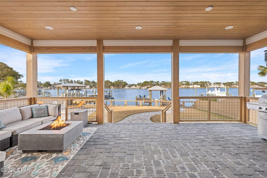 Custom built home has been thoughtfully designed with an open space concept and many upscale amenities. This spacious property sits right on The Grand Lagoon and is just a short walk to the beach. The Lagoon leads directly to the ocean and white sandy beaches of the Gulf of Mexico! Property sits in a quiet neighborhood with very friendly neighbors. It's very close to public beach access to which you can walk, ride a bike or drive a golf cart. Most furniture available for purchase. This home offers many conveniences including; 3 large bedrooms plus an office, beautiful bathrooms, a HUGE floor to ceiling 15' slider door that opens fully to reveal an exquisite outdoor covered porch that showcases the Lagoon, a private dock with lift, 2 jet ski docks, 3 car garage, Heated/Cooled salt water PebbleTec pool, infrared sauna and a beautiful Gourmet/Chef inspired kitchen/pantry.

When you first walk inside, you are immediately drawn to the focal point straight ahead through the 15' glass slider...The Lagoon. Open the slider to enjoy an open indoor/outdoor living space. Inside you'll enjoy an open space that encourages comfortable living and relaxation with a designated dining area, a gorgeous fully equipped chef inspired kitchen with a waterfall island. The HUGE walk around pantry has TONS of storage to keep kitchen counters free of clutter. The coffee bar is equipped with a wine/drink cooler, ice maker (great for filling up coolers for beach/boat day) and plenty of storage for adult beverages and drinkware. Enjoy cooking on the Italian (Fulgor) gas stove or make pizza's and artisan breads in the French Door oven.

The bedrooms are all large and can accommodate a king bed. The primary bedroom is very spacious and bright. Within this room, French doors will lead you into a spa-like bathroom that exudes tranquility. It includes a freestanding soaking tub, two separate vanities and walk-in shower with a skylight. The shower has dual shower heads; Rain Shower (comes from the skylight) & Wall with detachable hand held. From the bathroom walk directly into the 10x10 walk in custom closet. The laundry room is entered through the hallway OR through the master closet making it easy to put clothes away.

If looking as investment property; This comes with a fully built professional website, yard sign, linens, etc.

Possible owner financing available. Seller is owner and a lender.