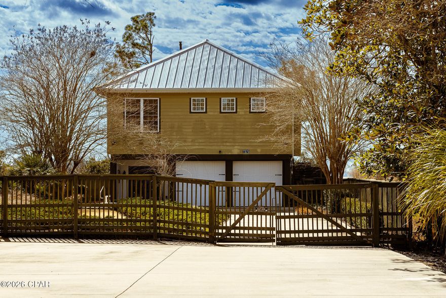 Custom-built in 2004 on 9′ pilings with 4′ of fill, this 2,172 sq ft, 3-bed, 2.5-bath home sits on the southeast corner of Fanning Oaks Peninsula with 50′ of frontage on Fanning Bayou/North Bay. Hardie board siding, 2020 metal roof, 2023 gutters, Rinnai tankless water heater, updated septic, and HVAC replaced in 2020. Open living with LVP flooring, built-ins, and bay views from every angle. Kitchen includes gas range, downdraft oven, double sinks, beverage fridge, under-counter fridge drawers, ice machine, pantry, and built-in hutch. Primary suite has dual baths, walk-ins, and office space. Extras include chair lift, dumbwaiter, screened porch, open deck, heated lap pool, and private dock with Gulf access. Lot is 0.47 acres, landscaped, fenced, and gated. Flood insurance approx. $990/yr. Assumable mortgage available.