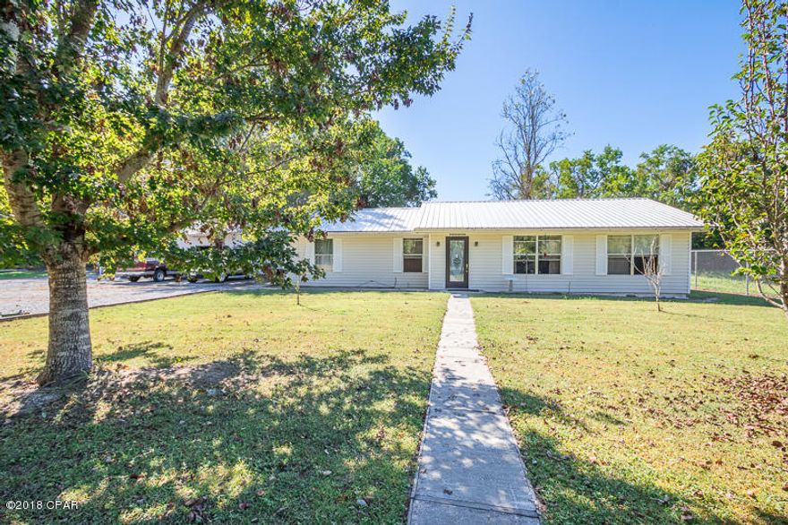 What's better than having the peacefulness of the country while living in the heart of Panama City?! This affordable 3bed/2bath home sits on a large fenced-in corner lot that measures just under an acre. You will love the amount of privacy this property has as nothing can be developed on either side. This home has tile floors throughout the kitchen, a new roof installed 5 years ago, a new AC installed in 2015, and a large covered back patio. Enjoy gatherings in the spacious great room. The kitchen/dining area features a breakfast bar, wood cabinets, and plenty of room for a large kitchen table. The master bedroom includes built-in drawers and a built-in gun cabinet. Another great feature of this home is the 24x30 workshop that includes a separate bathroom, electricity, and water. This lot also includes a pole barn covering a 24x36 concrete slab, and an electric gate entering the property. This home is conveniently located close to schools for every grade level. Don't wait to schedule a showing!