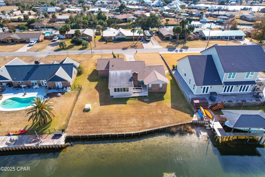 Gulf access with no HOA and Flood zone AE:

Welcome to this one owner 3-bedroom, 2-bathroom home, nestled in the golf cart-friendly Northshore area and near the city of Lynn Haven parks, community events and public boat ramps.
 With 2,185 sq. feet of spacious living, this property provides a fantastic opportunity to create your own updates and personalize it to suit your style. With Gulf access via the canal and North Bay, water lovers could enjoy the convenience of boating right from your backyard. 

The large foyer creates a welcoming first impression while the large open family room is perfect for both relaxation and entertaining, featuring skylights,  a wet bar and wood-burning fireplace.  A separate dining room adds a more formal touch.  The sunroom with tile floors overlooks the canal and is a peaceful retreat while birdwatching from the windows lining the room.  The kitchen has an island, breakfast area, pantry and an  entry to the backyard.  

Some of the windows have been replaced with double paned windows and all windows have attachable hurricane shutters conveniently stored in the garage.