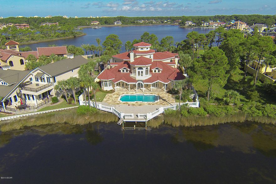 Experience unprecedented vistas from this outstanding bay front manor optimally located within the pristine gated community of Bay Point. This home has undergone a major renovation and masterful re-design including a new roof. Panoramic water views abound from the moment one enters the foyer with it's impressive 35' ceiling and vertically cascading balustrades that provide a grandeur that is unmatched. This open floor-plan concept is ideal for entertaining with highly functional living spaces spanning the first level with each space encompassed by beautiful floor to ceiling glass windows perfectly framing endless views of Grand Lagoon & Bay Point Marina. The chef's kitchen features custom cabinetry, ample windows for natural lighting, granite countertops, stainless steel appliances including a double oven & gas cooktop as well as a large breakfast nook and center island all of which looks over the rear pool deck and tranquil waterfront. The pool area was thoughtfully designed to maximize outdoor living space with expansive covered porches as well as exclusive private sun decks, this outdoor space is an oasis to enjoy the waterfront lifestyle. The master suite is located on the first level and provides both seclusion and tranquility with sweeping water views as well as ample space including a private sitting area, spa-like master bathroom featuring dual vanities, walk-in shower and private water closet as well as a large walk-in closet all with private access to the rear pool deck. Other notable features include travertine tile throughout, multiple outdoor terraces & balconies, wine cellar, sophisticated library, spacious 3 car garage with ample storage space as well as exclusive mother-in-law quarters with it's own private kitchen, two bedrooms and self sustaining layout. Bay Point is a master planned community in the heart of Panama City Beach close to shopping, dining and entertainment and featuring world class golfing, tennis, on-site marina as well as excellent proximity to St. Andrews Bay, Shell Island and the Gulf of Mexico.