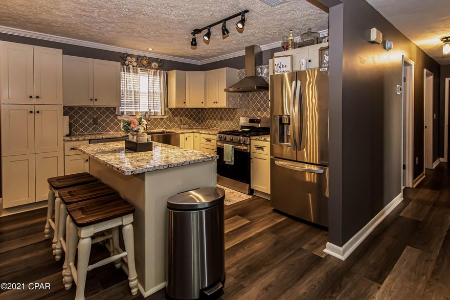 WOW!!  You MUST SEE this Gorgeous completely remodeled home in an established neighborhood close to shopping, restaurants, and Tyndall AFB! This home sits on a spacious lot and features a fenced-in, private backyard oasis as well as a Florida room complete with an indoor hot tub.  Over $85,000 in renovations last year to include new LVP flooring and custom crown molding and trim throughout. A completely remodeled kitchen with granite countertops, stainless-steel farmhouse sink, LG appliances, and soft close cabinets. Both bathrooms have been completely remodeled and feature herringbone marble floor tile, and a custom walk-in shower in the master bathroom. TOO MANY UPGRADES TO LIST HERE – ask your realtor for a detailed list, you'll be blown away!  New roof and HVAC in 2018.   WELCOME HOME! There's plenty of storage space available and room for dedicated workshop spaces in the two buildings/sheds in the backyard!  The back part of this property shows it's in an AE zone, however, the structures are situated above the minimum elevation and NO flood insurance is required.  The elevation certificate and survey are in the MLS documents.