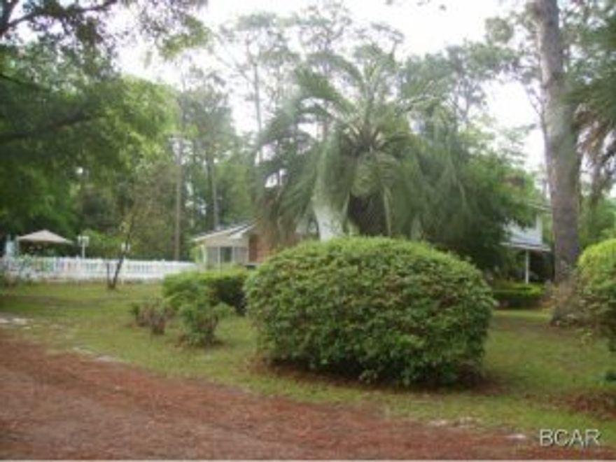 2.75 acres of beautiful land! Enjoy walks through the woods and watch the squirrels and wildlife play! Beautiful brick pavers accent the circular drive for this rare two story home with acreage and a garage just off of HWY 390. Live close to the city have have lots of room to roam. This a very rare and valuable piece of property going all the way to Florida Avenue. Great potential for an at home business. Home has a gorgeous living area with a fireplace, large bay window and state of the art kitchen we all dream about  The kitchen was updated with the very best designer oak cabinets, new dishwasher, nice appliances, awesome granite counters, and Florida room with fireplace  leading to the pool.  Seller has quotes for pool liner available, and will repair with acceptable offer prior to closing.   Pool has a pool storage room or changing room. There is one wood and one electric fireplace. There is a very large garage in the back of the pool area that has an upstairs that could be restored for living space or the whole garage would make a fine workshop! The home had a new roof in 2008. Behind the Florida room is the master wing of the house that has been completely updated with designer tile. The bedroom is large with a french door exit. The master bathroom has modern tile and fixtures, tub and separate shower done with intricate detail. This two story home is just off busy 390 yet so private and quiet. The home has four bedrooms, and the master suite is downstairs. A survey has been done. Location is the best! Just south of the new airport, convenient to stores and mall on 23rd st. and just across the bridge from the beach. Call for your personal showing today! Room sizes are estimated, county records do not show correct square footage per owner, please verify. Also, seller states acreage is 2.75 instead of 2.56 shown by county, verify all information.