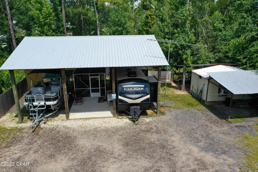 Are you looking for a get away that is walking to distance to the Chipola River at Lands Drive to launch your boat but without the fear of flooding? This could be it!!Property is set up with comfort and relaxing in mind. Partially fenced so you can bring your fur babies with no worries. It has a very large pole barn built with larger then normal poles for sturdiness or to enclose for your Barniminium! In one stall is the 2019 Keystone Cougar 33 foot with 3 slides that stays with property for the $99,900. One stall has the concrete patio for your covered clean enjoyment. It also has a 12 X 12 portable SCREEN ROOM..incase pest are a problem in the evening// Camper is like new!! All paved roads and you are 15 minutes from Mexico Beach and 20 from Port St. Joe. Location is great! ALL SIZES THERE IS ALSO ROOM AND POWER FOR TWO ADDITIONAL RV'S......... Both AC units are less then a year old!!! This RV was costume ordered with TWO refrigerators!!AND INFO ARE APPROXIMATE BUYER TO VERIFY AND TO CHEK FOR THEIR PERSONAL USE FOR PROPERTY.
