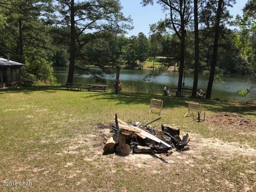 Amazing get away at a more amazing price! Located on a spring fed lake teeming with Bream & Bass, this is a must see. Complete with a 75x13 screened porch overlooking the lake, this home comes with a large kitchen with pantry & breakfast area, living room, huge family room with fireplace, tons of space with all new wood laminate floors. Master bath with both a large tub and separate shower. Also, a log cabin on the lakefront and dock along with a separate bunkhouse with bath. There is a greenhouse and a fully enclosed 28x24 metal pole barn and a pump house with lots of storage. All you need is fishing gear and bait! The 8.76 acres is partially cleared with huge oaks and room for a couple of horses. Ownership extends to the middle of the lake.