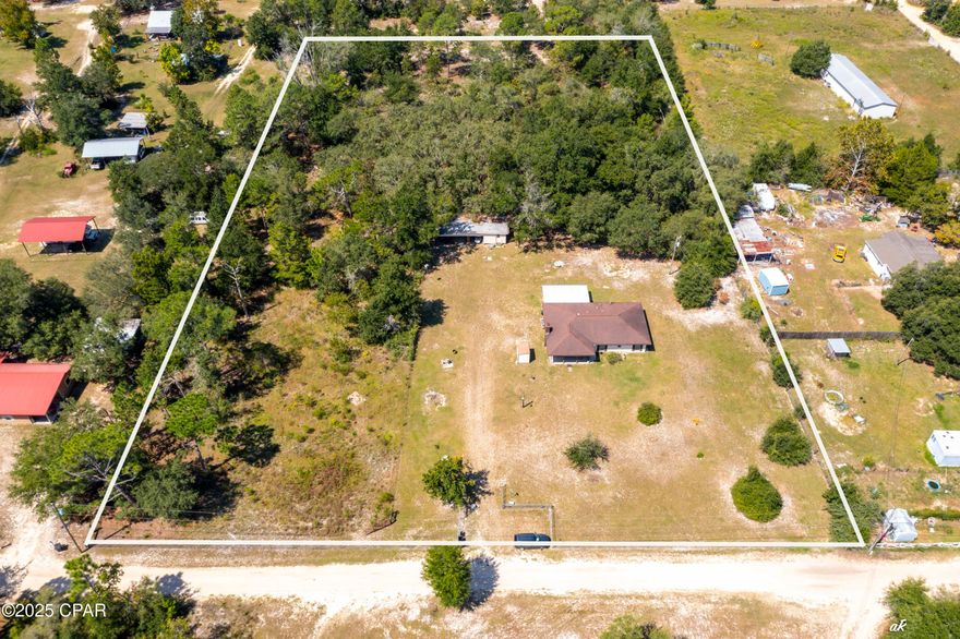 Looking for space and privacy but still want to be close to town? This 3-bedroom, 2-bath home sits on 1 cleared acre with 3 more acres of untouched land—all fenced and ready for whatever you have in mind. You'll love relaxing on the front porch swing or the screened back porch, and there's even some blueberry bushes for a little extra charm.

Inside, the kitchen has quartz counters (2022) and all new appliances (2022). Windows were replaced in 2023, HVAC updated in 2012, and a walk-in bathtub added in 2019. The home also comes with a Culligan water system (owned, not leased). Cozy up to the wood-burning fireplace, which currently has an electric insert, and enjoy the easy-care laminate and vinyl flooring throughout.

Property includes a 14' x 18' shop with three open bays—perfect for storing vehicles, boats, tractors, and more.

Built of block with stucco, this home is solid and move-in ready. You get the best of both worlds—peaceful country living with shopping and restaurants just minutes away.

All measurements are approximate; buyer to verify if important.