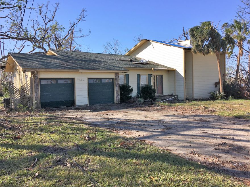 Investment Opportunity. Spacious five bedroom with three bathrooms. The downstairs recreation room could be converted to two additional bedrooms with closets in each. Solid cherry hardwood flooring and tile throughout. Granite kitchen counters and stainless appliances. Hurricane damage is limited to upstairs bedrooms and some in the rec room. Garage doors damaged as well (will need replaced). Back porch roof and supports will need fixed. Ironically, the trees that were blown down nearby now offers a decent water view from the backyard. Great neighborhood and close to Tyndall AFB.