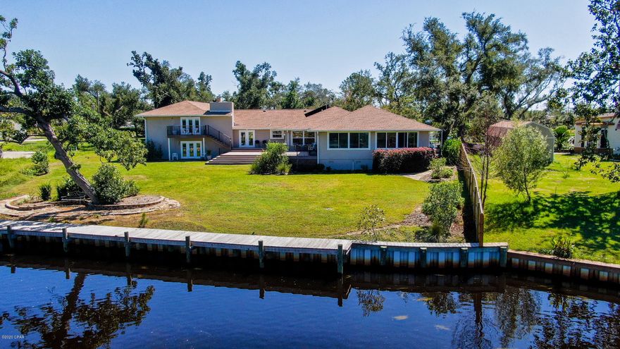 Currently under contract, seller accepting backup offers.  LARGE WATERFRONT WITH GULF ACCESS - Indoor pool, sauna, bonus room, very large office, atrium, fireplace with conversation pit, gulf access and more are just a few of the features that make this 4 bedroom 5 bath home a rare find.  The home has two true master bedrooms, one opens to the indoor heated pool and the other opens to a deck overlooking Pretty Bayou.  The home has a new roof, updated kitchen, oversized breakfast area and formal dining room. It has storage everywhere, a very large laundry room and solar hot water.  You can dock your gulf/bay boat in the water on one side of the lot and keep your canoe/kayak on the bank of the fresh water lake on the other side. Just 30 minutes to airport, PC Beaches and a short distance to schools, shopping and entertainmentMeasurements are approximate, verify if important.