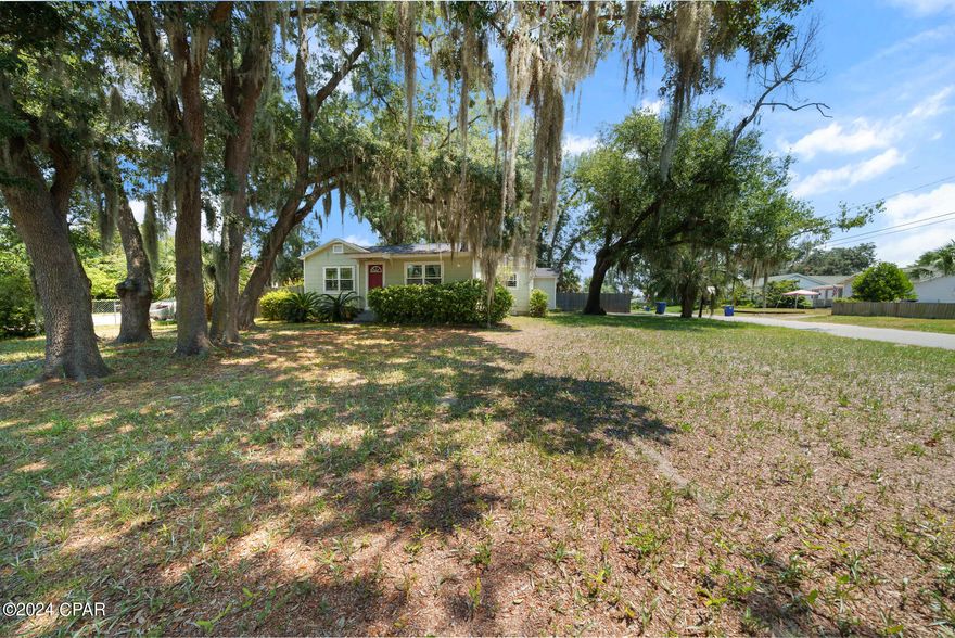 Charming 1943 Bungalow in the Desirable Cove Area. Nestled on a spacious triple lot, this 2 bedroom with 1 flex room is an enchanting bungalow that offers classic charm in the highly sought after Cove neighborhood. Featuring an updated kitchen and bathroom, this home boasts cherry wood floors throughout, abundant natural light, and a large fenced backyard with a spacious work shed and extra parking. A new roof and energy-efficient air conditioner, both installed in 2019, ensure modern comfort. Enjoy cozy evenings by the working fireplace. Additional features include a detached one-car garage for extra storage as well as an outbuilding with covered parking. Located in the desirable Cove area, surrounded by oak and magnolia trees with draping Spanish moss. Make your appointment to see this one today!