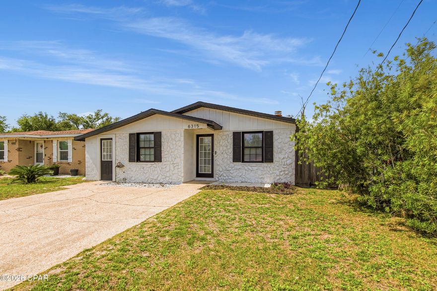 Welcome home to this beautifully updated 3-bedroom, 2-bath rental offering the perfect mix of modern style and everyday comfort. Conveniently located just minutes from Tyndall Air Force Base, shopping, dining, Walmart,  and local restaurants, this home makes commuting and daily errands easy. Inside, you'll find a bright open-concept layout with plenty of natural light and a cozy fireplace that creates a warm, welcoming atmosphere. The main living areas feature luxury vinyl plank flooring, while the freshly painted exterior adds great curb appeal. The updated kitchen is designed to impress with stylish cement countertops, a clean white backsplash, colorful cabinetry accents, stainless steel appliances, and a large island complete with a built-in wine cooler. It flows seamlessly into the dining area, making it perfect for entertaining or everyday living. Both bathrooms have been refreshed in recent years, including updated toilets and an upgraded primary shower, giving the home a clean and modern feel throughout. Step outside and enjoy the oversized fully fenced backyard featuring a large patio that is ideal for relaxing, entertaining guests, or enjoying quiet evenings outdoors. A powered storage shed provides extra space for hobbies, tools, or additional storage needs.