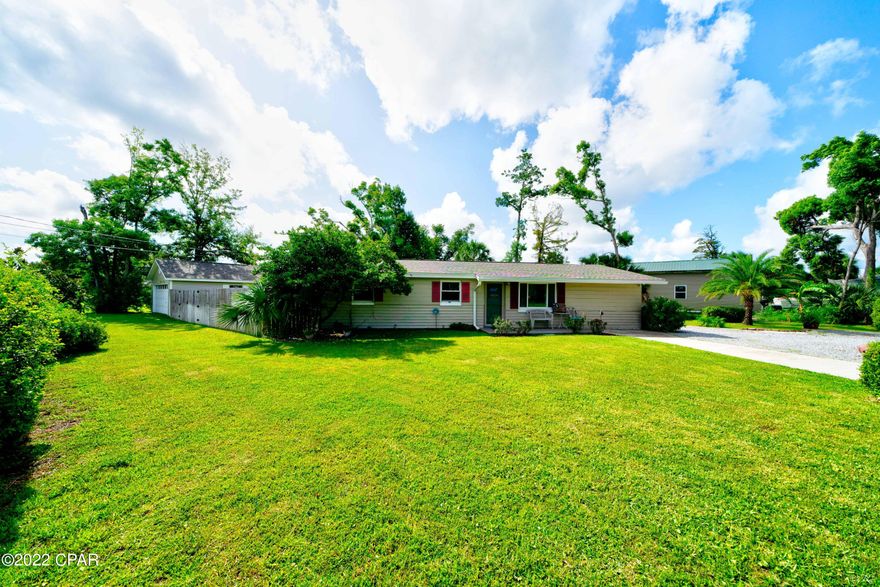 ONE BLOCK FROM THE BAY!! CORNER LOT!!! This 4/2 adorable home with a massive fenced in back yard, mature landscaping and circular driveway is FOR YOU!! The detached garage is OVERSIZED, comes complete with built in cabinets, and a second driveway!! The roof was replaced in 2018,  A/C in 2020, water heater one month ago! Windows and sliding glass door in 2013. The tile floors throughout the main living areas are gorgeous! Interior has been Freshly Painted! Feel secure in any storm.....BLOCK construction!!! Location is amazing - walk to the Bay OR drop your boat at the boat landing - 1000 FEET AWAY!!  Great schools, close to shopping.....Lynn Haven is the place to be!! Call your favorite Realtor to see this one TODAY!!! Sizes to be verified by the Buyer.
