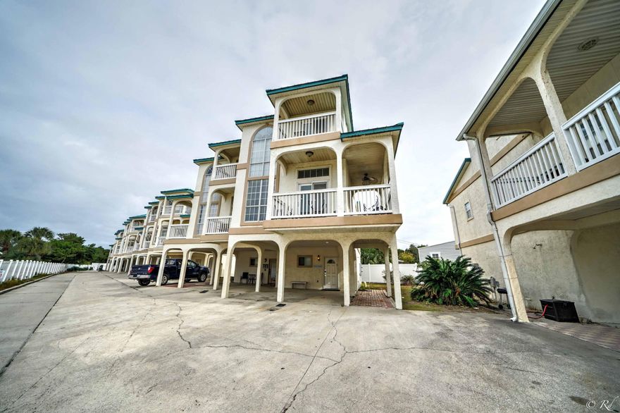 Spacious 3 bed/3 bathroom townhome in The Palms.  This unique 3 story townhome would make a perfect home away from home or rental property. There is a lock-out efficiency suite on the bottom floor with kitchen and closet.  The second floor hosts the main living area with a wraparound balcony. Also situated on the second floor is the full sized kitchen equipped with stainless appliances, granite, backsplash, and beautiful cabinets. The guest bedroom and full guest bath are also on the second floor. Large windows go all the way up to the third floor. Enjoy Gulf views from the master bed/bath suite on the top floor. The master features a loft and fireplace. The master also has custom cabinets, granite and a jetted tub that duly serves as a shower. Just a few steps to community pool and GULF! 2 parking spaces and a golf cart parking space included.