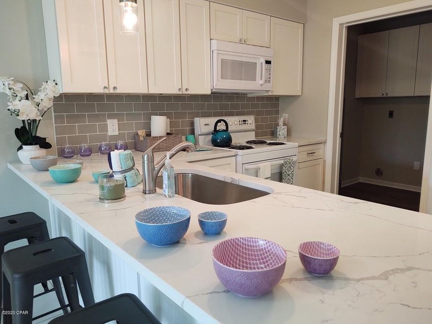 Located on the Gulf side of Thomas Dr. Steps to the beach and public access #20.  Beautifully remodeled townhome. Kitchen boasts with all new cabinets, white granite counter tops, ceramic tile floors , white appliances. Large laundry room located off of the kitchen with new cabinets. Master bedroom has updated double vanities with new counter tops. Hardwood flooring throughout the upstairs bedrooms. All new light fixtures throughout.  All new paint inside. Brand new A/C. The back yard has separate outdoor shower and storage. Privacy fenced back yard with swimming pool for the resort. Second floor master bedroom has a peek of the ocean. HOA includes garbage pickup twice a week, basic cable with HBO, lawn maintenance, pool maintenance, HOA insurance. Inside and outside pest control. Each unit has one dedicated space and any additional cars can use the "Guest" space. All measurements are approximate.