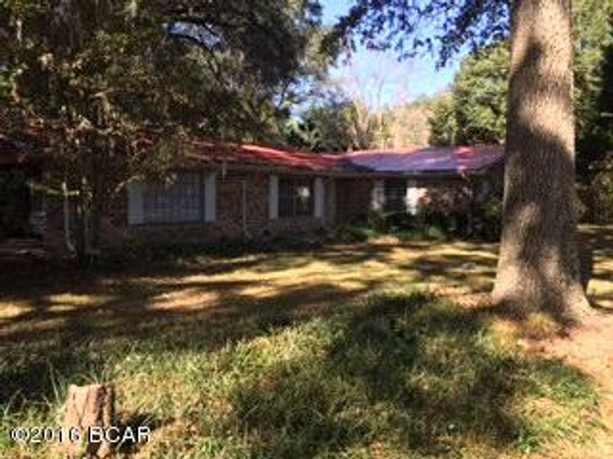 Welcome to peace and quiet, this 3/2.5 spacious, country home sits on 10.1 +/- acres. Kitchen features lots of cabinets, a eat-in bar and walk in pantry. The oversized den/family room has a wood burning fire place and walks out onto a wood deck that has a attached wheelchair ramp. Master bath has double sinks and a handicap shower. Large open Dining/ Living Room located at the front of the home. Updated metal roof. Nice, handicap accessible screened in sun porch with entryways to kitchen, backyard and 2 car carport. Outside features are asphalt driveway, pump house/ Workshop, bay barn with metal roof. Greenhouse, was a former nursery, in need of some repairs. A variety of beautiful landscaping and various plants/ trees. Located minutes from I-10, Wal-Wart and Restaurants. Call for your viewing today!