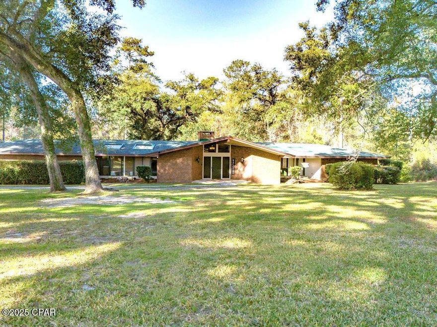 Welcome to the Craven House! This Frank Lloyd Wright-inspired, architect-designed, mid-century modern landmark—is one of Chipley's most recognizable historic residences. Originally built in the 1960s for Dr. James B. and Virginia Craven, this National Register property was designed to evoke a bird in flight, with bold horizontal lines, sculptural geometry, and a seamless connection to nature. Featuring 4 bedrooms, 3.5 baths and bonus room, this residence retains the charm of its original mid-century architecture, beautifully preserved throughout. Interior features include wood ceilings, stone accents, an oversized living room with wood-burning fireplace and original built-ins, dining room with a full wall of windows, and a kitchen retaining its original cabinetry and authentic mid-century layout. All 3 full bathrooms showcase original tile, wallpaper, and built-in vanities, offering an untouched period aesthetic rarely found today. Significant updates include plumbing throughout, electrical panels (3-phase), two HVAC systems (5-ton 2016, 3-ton 2017), water heaters, encapsulated crawl space, and a shingle roof installed in 2018. The exterior boasts an attached 2-car carport, massive, screened back porch, 24′ saltwater pool with decking, and a solar-powered entry gate. Don't miss your rare opportunity to steward an iconic piece of mid-century architecture—livable art preserved with extraordinary care.