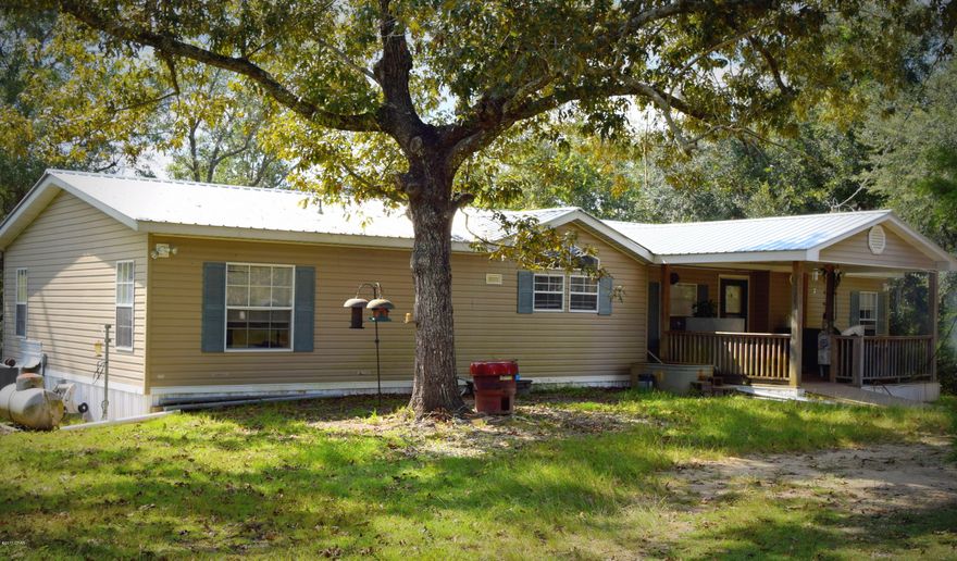 Secluded down a private drive sits this spacious 3/2 home on over 18 wooded acres. House features large master suite with walk-in closet, dining room, wood burning fireplace, spacious kitchen with island and breakfast bar overlooking the living room. Outside you will find an attached front porch, detached carport, pole barn, storage sheds, milled asphalt drive way and a  shipping container that has been converted into a storm shelter, equipped with air conditioner, bunk beds and toilet. Property is located approximately 10 minutes northwest of Bonfiay city limits.