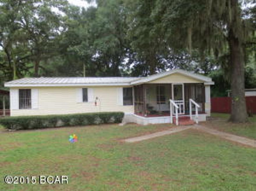 Warm and inviting are words that come to mind when you enter into this home. Pride of ownership shows everywhere you look. The seller has taken very good care of this home and it shows. Home sits on 2 lots completely chain link fenced with a detached carport on a concrete pad. Home offers a formal living room, family room with wood burning fireplace, kitchen with breakfast bar, dining area and 3 bedrooms 2 baths.  All appliances convey including the washer and dryer. The home is all electric with city water, a well for the sprinkler system and septic tank. The A/C unit is maintained by Brook Brothers and just had a checkup last week. The large back yard has a huge fig tree that currently has figs. The screened in front porch is a perfect place to have your morning coffee while watching the