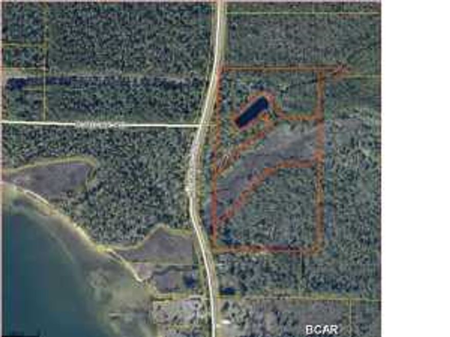 PREVIOUSLY SOLD FOR $300,000 IN 2006, 24.5+- acres ACROSS THE STREET FROM THE EAST BAY, 16 acres of dry land and 8+ acres wet land. BEAUTIFUL POND AND CREEK IN CENTER OF LAND. LOTS OF TREES TO BUILD IN THE SHADE. SEE AERIAL PHOTOS ATTACHED BY CLICKING ON THE MAIN PHOTO. Information taken from tax records and should be verified by buyer. Seller has no knowledge of restrictions etc.