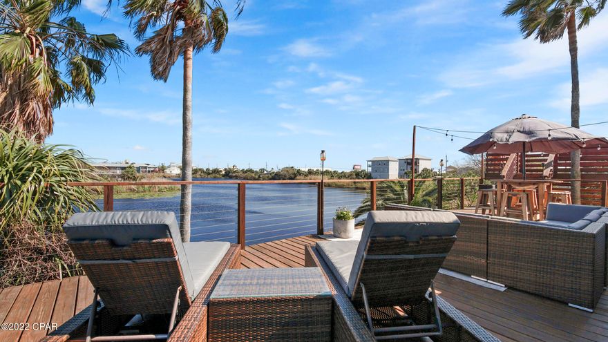 CURRENTLY UNDER CONTRACT, SELLER ACCEPTING BACKUP OFFERS. Lakefront home 165 steps to direct beach access #77! This exquisitely renovated home is currently owner occupied but will make an outstanding vacation rental; 4Br/3Ba already set up to sleep 17 & sold fully furnished. Attention paid to every detail: quartz counters, tile  & vinyl plank flooring, shiplap & wainscoting, elegant fixtures, and furnishings. The home comes furnished with Beds, Bunks, KitchenAid appliances, Living/Dining furniture, and deck furniture. 1,825sf of lakefront decking over 3 levels! Relax lakeside on the lowest level with bench seating & firepit. Enjoy your morning coffee on the 3rd level with peekaboo views of the Gulf. When not at the beach, enjoy paddling around the lake & fishing since the home comes with SUP boards, kayaks, canoes, & paddle boats. Record size bass and brim in this lake! On the other side of the lake is a bar/restaurant; walk or paddle to it if you don't feel like cooking. Unlike many vacation rentals, this place has plenty of parking! 2 single car garages and lots of driveway space. The garages could be converted into a second kitchen area, bed & bath, or game room easily to maximize rental potential, and you will still have plenty of parking space. This home is a must see! You will not be disappointed. All measurements are approximate, verify if important.