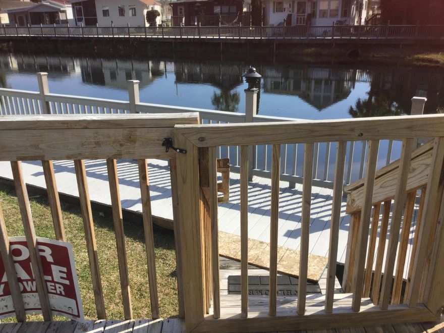 This is an incredible property.  This home brings immediate occupancy to a whole new level.  All you need to bring is food and clothes.  Everything else is already there.  This waterfront home features a beautiful deck overlooking the water, a screened porch and a huge living room with windows all around covered by custom drapes.  The lot is larger than most. The windows have been treated to withstand 100mph winds.  This home sits in a gated community with low HOA fees.  It has 2 pools 1 is heated, a clubhouse and a catch and release pond right out the back door.  This home provides a relaxation haven.  Away from thenoiseofthecrowds but just minutes from great restaurants and shopping.  Then, as if you needed. More, the worlds most beautiful beaches are just a short drive away!.  WOW!!!