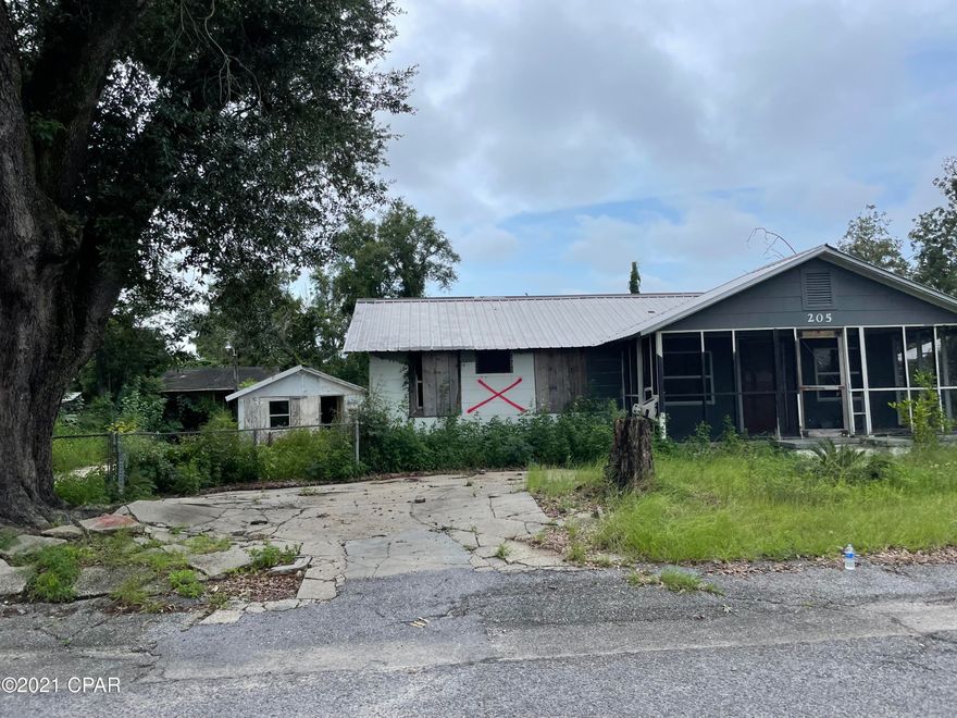 This home has sustained damage from Hurricane Michael and a previous housefire. There are several yard buildings on the lot including a 2 car garage, a workshop and a gazebo. The home and structures could be restored. This .3 acre lot would make a fantastic residential building lot with plenty of room to build if the home is demolished. There is a concrete pad with electric, city water and city sewer available. This property is located near the Bay, restaurants, schools, parks, public boat ramps and more. The two bedrooms are currently accessible from an outside door. You can still see the doorframe that can be opened back up to the main home for a more convenient access.