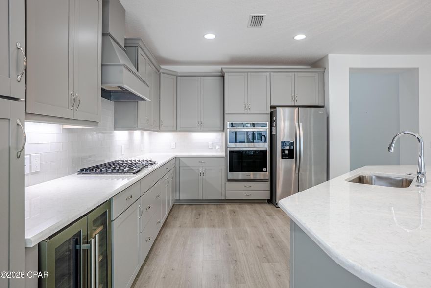 PRICE IMPROVEMENT!!!!   Welcome to effortless resort-style living in Margaritaville! This  exceptionally well-maintained, highly desired Breeze Bay floorplan, corner-lot home offers 3 bedrooms and 3 baths with beautiful vinyl plank flooring throughout for seamless style and continuity. The chef's kitchen shines with quartz countertops, tile backsplash, wine cooler, gas cooktop, wall oven and microwave, plus an oversized island that flows into the dining and great room--perfect for entertaining. A full wall of glass sliders opens to the lanai with tranquil pond views, creating an ideal gathering space indoors and out.
The primary suite overlooks the backyard and features a luxurious en-suite with a stunning shower and dual quartz vanities. Two secondary bedrooms provide comfort and privacy, including one with its own en-suite--perfect for guests. All appliances convey, including washer and dryer, along with custom blinds and window treatments. Garage floor and lanai have been epoxy coated and sealed. Extra storage cabinets in the garage.  A whole-house generator adds protection and peace of mind. 
 Enjoy a 55+ active adult paradise offering world-class amenities, resort-style pools, fitness center, Pickleball and tennis courts, dining, entertainment, and a golf-cart underpass to explore it all with ease. Adjacent to the community is a coming soon Publix grocery store, shopping, dining and more! A state of the art medical complex is being built with medical office already open and a new 180 bed hospital proposed to open in 2027. The HOA fee includes all lawn care, amenities, activities year round & more.This is Margaritaville living at its finest!