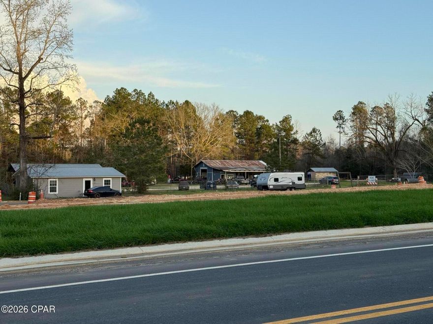 This is a wonderful opportunity to own 3 acres on a very busy road just outside of Wausau Fl. on HWY 77 Endless possibilities with this property that has income producing properties already , has a 3 bay garage and a 1 bedroom house that has been completely remolded. Let it pay for itself or remove the buildings and start new. With the new four lane highway being finished up ,makes this a great place for any type business. Call today for more details.  Land and buildings only