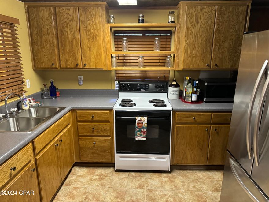 You've got to see this cool fishing camp sitting on almost a one acre lot in the center of the community of Howard Creek.  The cottage has been built onto over the years and features 2 bedrooms plus a bunk room, 2 full baths, 2 living areas and even two kitchens.  It's great for a large family or friends vacationing together.  There is also so much to do outdoors and there is a big fire pit and sitting area in the backyard.  There is a building that once housed a smokehouse and summer kitchen but it needs updating.  There is an oversized 40x40 garage with 2 large overhead doors on front and another on the side.  Tons of space and there are two bedrooms and 2 full baths above the garage as well. 
 The entire parcel is fenced and gated at the end of the road and very private. 
 Howard Creek is nestled along the Brothers River.  This leads into the Apalachicola River or take the intercoastal waterway out into the Gulf of Mexico.  Some of the best fishing anywhere!  This community is golf cart friendly and golf carts are in fact the preferred method of transportation.  There is a country store, church, and an incredible county park with paved boat ramp.