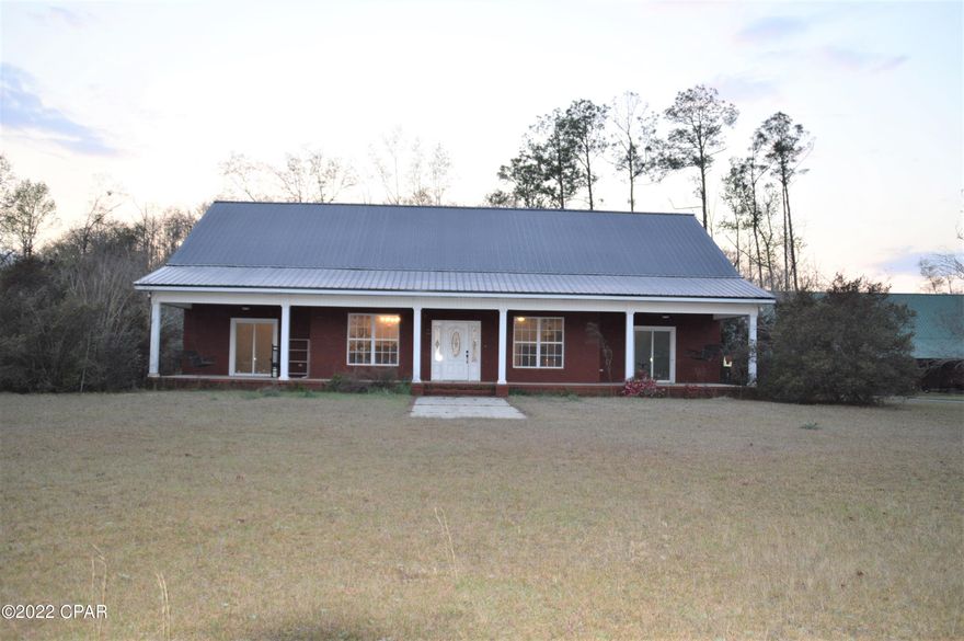 Spacious 3/2 brick home on two acres in quiet country setting. Open floor plan with plenty of room for entertaining. Master bedroom features walk-in closet, ceramic tile double shower and jacuzzi tub with separate water closet. Listen to the crickets on the wraparound front porch in your porch swing or rocking chair. Large carport with room for several cars and boats. Giant 1,500 square foot barn with loft and lots of room for a workshop or storage. Barn has a 75 x 14 lean-to for storage. Home is easy to maintain with all brick, vinyl and concrete surfaces and recent metal roof.