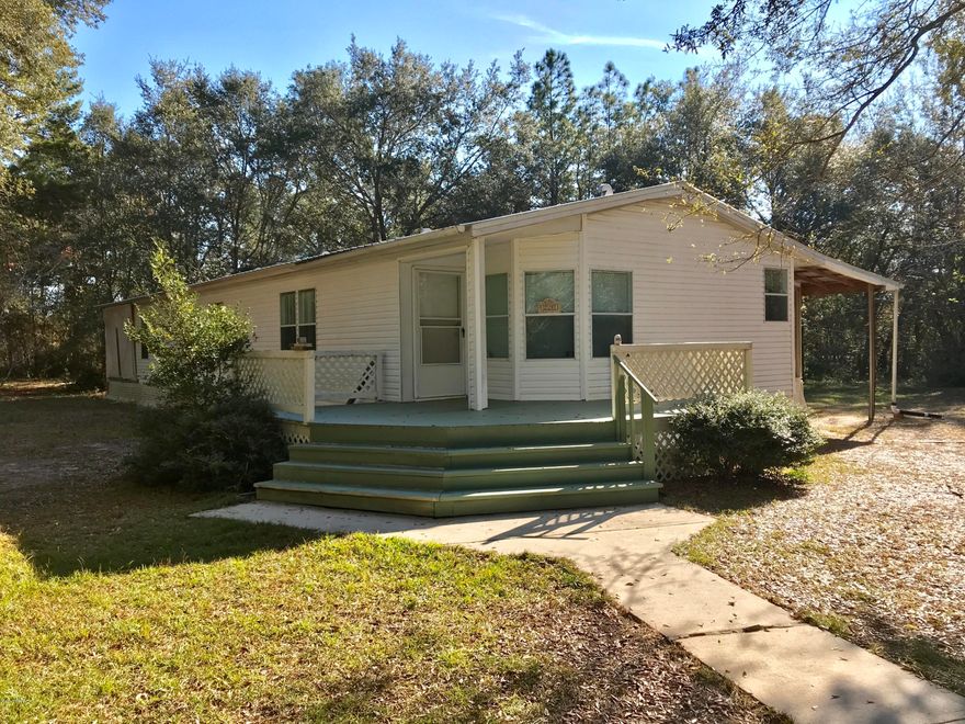 Beautiful home on 3 acres with paved roads! This immaculate 2 bedroom, 2 bathroom home offers a dining room, wrap-around kitchen, breakfast nook, full office space, STORAGE GALORE!, walk-in closets, built-in craft table, and a built-in spa on a HUGE screened in porch. The property features a greenhouse with running water and electricity, an attached building which houses laundry and additional storage space, a barn/3 car garage, as well as big, beautiful live oak trees scattered amongst the full property. New metal roof and A/C unit replaced in last 2 years. This home is truly one-of-a-kind and a rare find for this area. All measurements are approximate and should be verified by buyers.