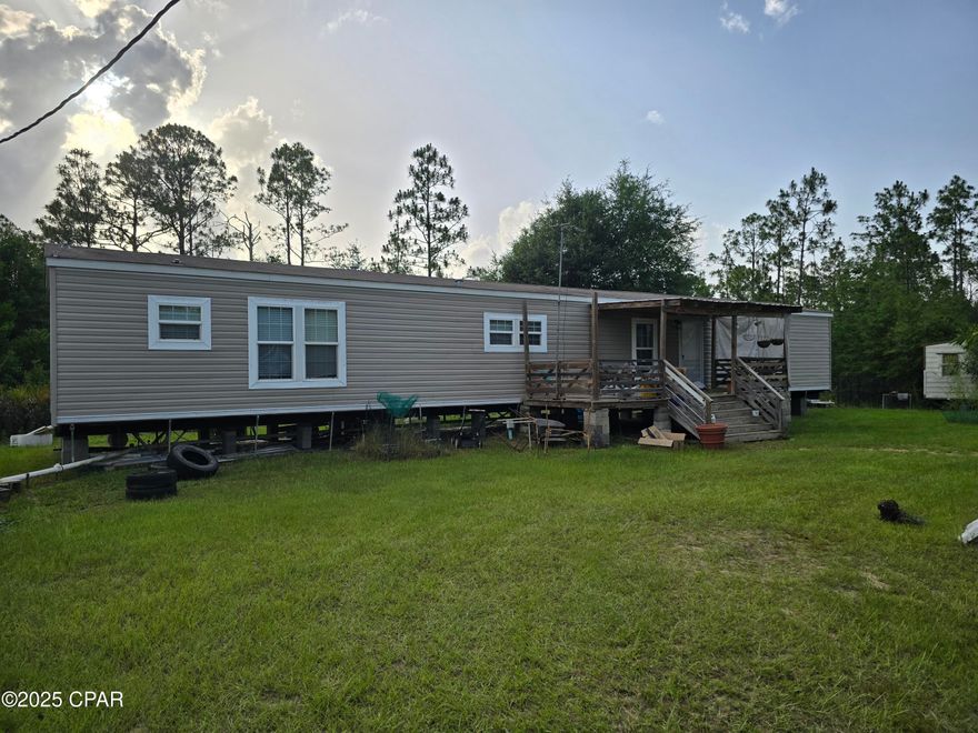 Includes 2016 Cavalier MFG Home that has a large master, split floor plan, separate laundry area, this home boasts space, with a beautiful kitchen. Enjoy the grand staircase to the first floor deck that is partially covered. Home on land with barns and shed. Yard is fenced around with access gates.  Yard has a pond, barn, greenhouse, fruit trees, ample parking, extra rv hookup area (partial hookup can be made full). County living near McCormick Lake and the Mossy Head library is near.  Easy access to Blountstown, Panama City. Show anytime.