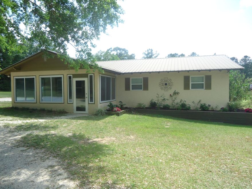 MOVE IN READY!!  This 3/2 with updates like a metal roof, new stove, hard surface countertops, new carpet and fresh paint make this a turn-key house.  It sits on 2.48 acres with a pole barn that has 24 x 24 concrete and 12 x 24 on sand, and has electricity.  Part of backyard is fenced with a nice back deck that is ready for relaxation.  All this on a paved road and close to the Mill Pond.