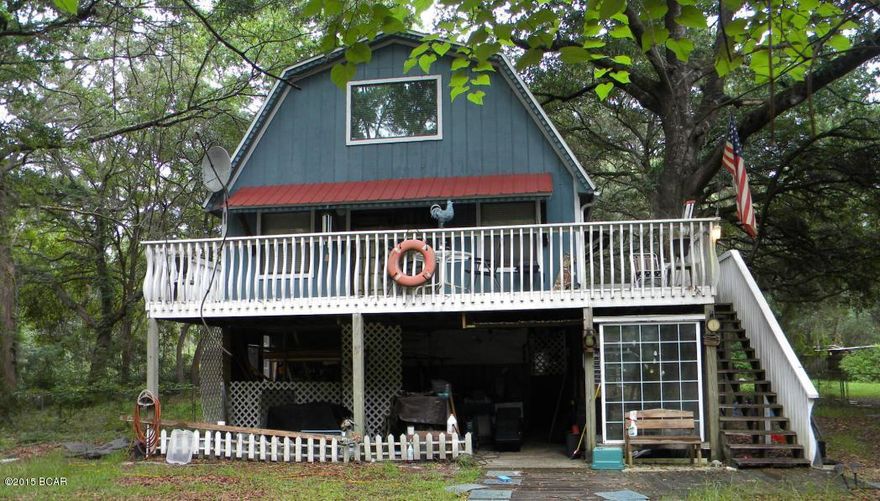 This three story, barn style roofed, corner lot home is located on a quiet country paved road . Launch your  boat from a nearby public ramp for a day of fishing on Deerpoint Lake. Lake can be partially seen from house.  The nearly 3/4 acre lot is chain link fenced and cross fenced, along with a 12 x 12 x 7 dog box, ideal for keeping livestock with the only restriction being no swine.  Large Oak and Magnolia trees, help to keep home cooler in the warm months. Living areas, bedrooms and bathrooms on all levels provides  a great deal of storage space and flexibility. The 1st floor has a separate kitchen from the kitchen on the 2nd floor, along with living space and additional storage; useful for extra guests or family member. The bathrooms on the 1st and 3rd floor have showers, the 2nd floor bathroom has a tub. The seller was told the water is supplied from a 240' deep well. There is a workshop in the back with electricity to it.