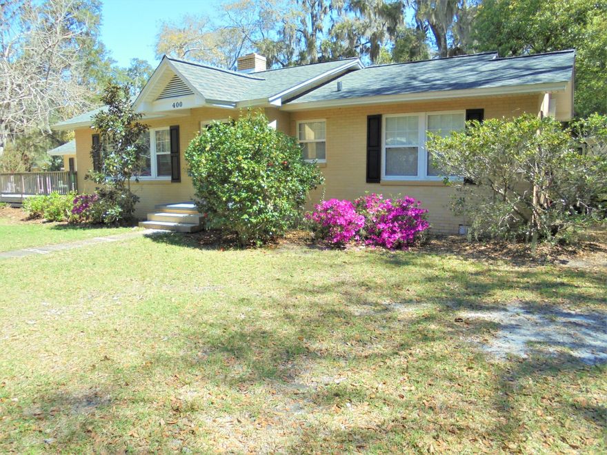 Charming Cove home that sits on a beautiful, large corner lot, with beautiful oak trees and an alley access. Convenient to Bay Medical, downtown, and Tyndall AFB, as well as a bike ride or walk to enjoy a sunset or fireworks on St. Andrew's Bay. The home features a desirable split floor plan with a master suite that is hard to find in the Cove. The home offers offers two large living areas, painted brick, hardwood floors and LVT flooring in the family room. There are two fireplaces and a lovely dining room with a built-in glass china cabinet. The kitchen is updated and very functional, and there is a very nice size laundry room. There are many extras that make this home special on the outside, all brick exterior, a front deck, nice covered carport for parking and an attached workshop. There is also an additional covered parking space and two storage sheds that come with the property. This home is the one you have been waiting for in the beautiful classic Cove neighborhood! Square footage is approximate - if important please measure.