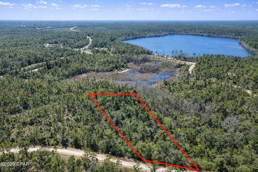 Discover your own slice of North Florida living with this ±2-acre parcel (survey available) in the desirable Compass Lake in the Hills community. Offering space, privacy, and flexibility, this property is well suited for a future homesite, weekend retreat, or long-term investment in one of Jackson County's most versatile recreational neighborhoods.

Located on a quiet dirt road, this high-and-dry lot provides ample room to build while enjoying the balance of rural living and optional community amenities. Compass Lake residents have access to a clubhouse with pool, a German restaurant serving lunch and dinner, tennis courts, horse facilities, frisbee golf, and miles of scenic roads and trails.

Outdoor enthusiasts will appreciate access to two lakes: McCormick Lake, a private lake reserved for residents, and Compass Lake, the larger of the two, located near the clubhouse. Compass Lake allows motorized boating, jet skis, kayaking, fishing, and features a boat dock for easy access. Nearby, The Cove snack shack often hosts live music, creating a laid-back lakeside gathering spot.

The generous size of this parcel allows for a variety of residential building options in accordance with county requirements, with horses permitted and an optional HOA. For those seeking additional privacy or expansion potential, this lot connects at the rear boundary to a neighboring 5.4-acre gated property, offering a rare opportunity to assemble a larger private estate.

Conveniently located within approximately 7 miles of I-10, the property is about 30 minutes from Panama City and 40 minutes from Dothan, Alabama, making it easily accessible while still feeling tucked away.

With plenty of room to build and a strong sense of community, this property blends space, recreation, and location—an excellent opportunity to own land in one of North Florida's most established lake communities.

Buyer to verify all building requirements, zoning, setbacks, utilities, and community amenities. Some amenities may require optional membership fees.