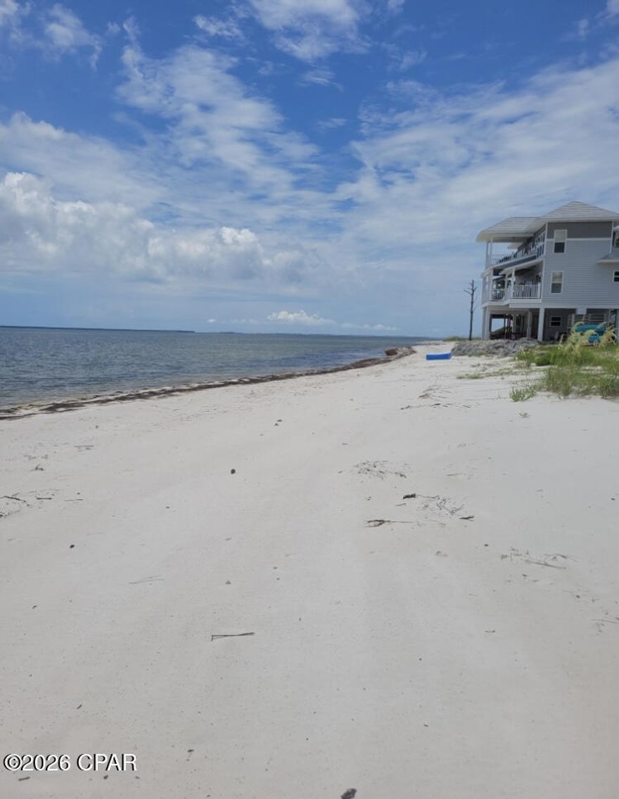 Stunning Beachfront one acre Lot in private gated Hidden Beaches community with Panoramic Views. Experience breathtaking sunrises, sunsets, and star-filled nights from this exceptional 150' of white sand beachfront lot. Enjoy unobstructed views of St. George Island, Dog Island, and the Gulf pass. On the sandy shoreline, watch dolphins play, spot eagles and shorebirds, and even see migrating manatees. Fish from shore, kayak, paddleboard, or swim in the protected sandbars. Shore breezes keep it comfortable, and nearby boat ramps provide easy access to renowned fishing waters.  Located minutes from Apalachicola, St. George Island, and Carrabelle, you're close to dining, shopping, and St. James Bay Golf Club. Central to Tallahassee and Panama City, with nearby nature destinations like Wakulla Springs, Tate's Hell, and St. George Island State Park for hiking, birdwatching, and outdoor adventures.  This 397' x 150' prime building site is a gated community with a $33 per month HOA. A dock is possible with a permit. Waterfront lots like this are rare, and conservation land across the highway ensures lasting privacy. Own your piece of paradise on Florida's Forgotten Coast!
