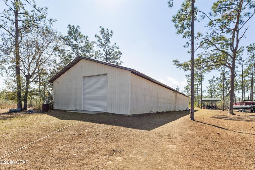 If you've been searching for a truly unique piece of land this 10-acre fully fenced property is exactly what you're looking for! Tucked away among maturing trees this property is ideal for a man cave retreat, hunting property, homestead, or as a temporary residence while you build your dream home.
At the heart of the property is an impressive 40x100 shop featuring two 12-foot roll-up doors, three 220-volt electric hookups, RV sewer connection, and a wood-burning stove, making it perfect for large equipment, RVs, workshops, or recreational use.
Inside the shop is a 550-square-foot efficiency living space with a full bathroom, electric tankless water heater, and as a remarkable bonus the living area is also a storm shelter constructed of cinder block walls and a 6-inch concrete roof. It survived Hurricane Michael with no issues, offering you peace of mind you won't find elsewhere.
The land itself is equally impressive. In the last few years, the seller has planted 30 oak trees and 248 pine trees, creating a beautiful, wooded setting that continues to mature year after year. A small orchard includes orange, pear, avocado, tangerine, banana, peach, plum, mulberry, lime, and lemon trees. The orchard area is already fenced and set up for raising chickens-perfect for a self-sustaining lifestyle.
Additional features include three pole barns providing ample storage, along with both a deep well and a shallow well, plus a septic system. The property also includes a stocked fishpond and a designated shooting area. There are also frequent wildlife sightings, including deer, a momma bear with her cubs, and the occasional wild hog.
This property offers both privacy and possibility all in one incredible package. Whether you're looking for a recreational retreat, a secure base of operations, or a place to live while you build, this land is ready to support your vision.