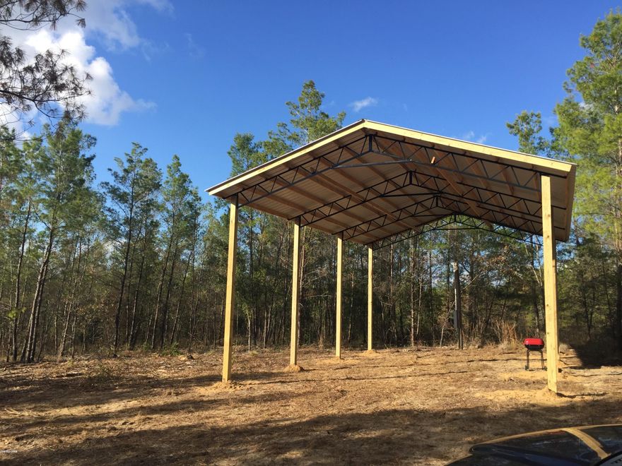 Quiet Vacant Land about approximately 500 feet off a paved road.  Just under 5 acres on a spring fed lake. Pole Barn  and  pole for power hook-up. Wild blueberries, and wildlife as well.   There are no utilities on the property.