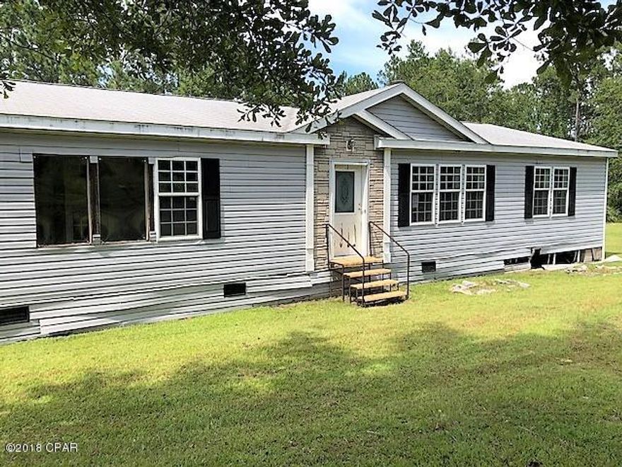 This large doublewide is on one acre of land in the country.   You have room for  a small garden and pets.   The home features 3 bedrooms and 2 baths with split bedroom design.  The large living room has a pretty fireplace.  There is a large metal utility building and another shed that houses the well and pump.  It would make a good investment property.