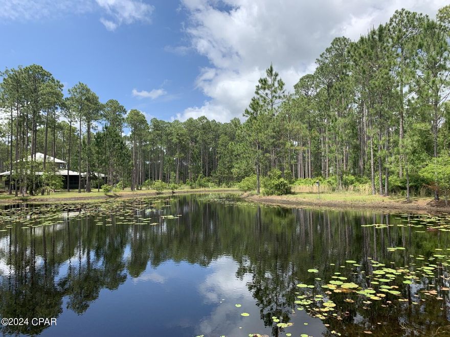 Wow! 1 acre pond Lot in RiverCamps listed at $150,000. You will not find a better deal than this in RiverCamps. There are no wetlands within the large buildable area providing plenty of room for your custom home. Survey is available. Tremendous opportunity to own in RiverCamps, a nature enthusiasts dream. 1500 acres, less than 450 homesites and 1000 acres committed to conservation. Wildlife abounds in this waterfront community. Surrounded by 18,000 acre West Bay, Crooked Creek and the IntraCoastal Waterway you will have direct access to Shell Island and the Gulf of Mexico with a 30 minute boat ride. RiverCamps boasts it's own community boat ramp and owners enjoy day-use boat slips and dry storage for your boat. This golf cart friendly community has 7 miles of connected trails and is conveniently located less than 10 miles from Pier Park and the famous white sandy beaches and 10 minutes from NW Florida Beaches International Airport. 
Please contact listing agent for latest updates on the rebuild of our amenities.