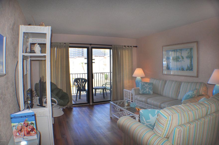 CURRENTLY UNDER CONTRACT, SELLER ACCEPTING BACKUP OFFERS.  Pretty view of the pond and gulf from this 2BR/2BA Sugar Beach condo.  Updates include new wood flooring, refinished kitchen cabinets and new countertops, fresh paint, new vanities in both baths, and new AC and hot water heater.  The unit overlooks the Sugar Beach turtle pond and you can see the Gulf of Mexico from the balcony.  Immaculate and well taken care of, this would be a great investment property or second home.  Sugar Beach is a very popular gulf front complex convenient to so many restaurants, golf courses, shopping and more.  Amenities include a large pool, clubhouse, barbecue grilling area, tennis courts and a dedicated beach.  All info is approx. and must be verified by Buyers if import.