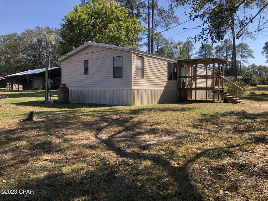 Come live in the country, on approx 4.97 acres in this Nice 2 Bedroom, 3 bath double wide mobile home perfectly nestled in Bonifay, Florida and located in the heart of the Panhandle of Florida.   Previously used as an income producing rental property, but ready to become a permanent home for someone.  This home boasts two Living Room areas, with one that could possibly be converted into a 3rd Bedroom if needed.The open floor plan allows for a full view of the Kitchen and Dining Area, great for entertaining.  Enjoy the front porch to relax in the shade on the hot Florida days, or for early morning coffee.  Plenty of storage space in the open pole barn and storage shed.  The additional acreage provides for a great place for ''get togethers'', or possibly additional future development.
