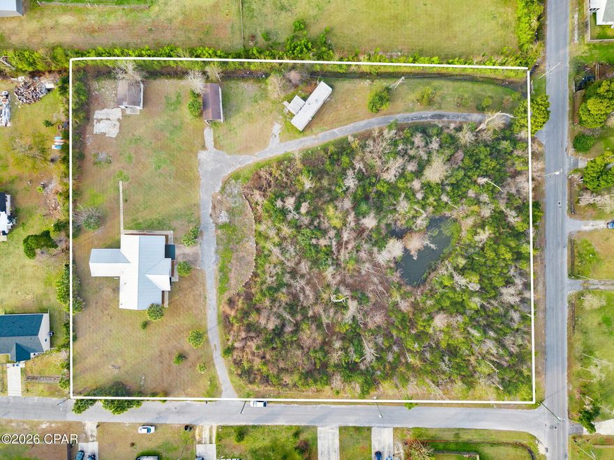 2.88-acre multi-residence property located in the heart of Panama City. Offering exceptional space, privacy, and versatility, this sprawling estate is ideal for multi-generational living, investment income, or a private retreat with room to grow.
The main residence is a fully renovated cinderblock home featuring three bedrooms and 1.5 baths, plus a dedicated mother-in-law suite. The home has been thoughtfully updated from top to bottom with modern finishes, including:
- New flooring and fresh paint throughout
- A durable metal roof
- An updated kitchen with new appliances
- Completely remodeled bathrooms featuring new vanities, toilets, and a brand-new soaker tub.
Bright, open, and built to last, this home is truly move-in ready!
Adding potential value is a separate 2-bedroom, 1-bath mobile home. With some TLC this would be ideal for extended family, guests, or rental income. 
The property continues to impress outdoors with a detached 2-car garage for vehicles, storage, or a workshop,
Large pole barn, perfect for boats, RVs, equipment, or hobbies and a serene pond nestled at the center of the property, surrounded by mature trees, creating a peaceful natural retreat.
The Property features expansive open land with established driveways and multiple access points.
Enjoy the privacy and space of country living while remaining just minutes from shopping, dining, schools, and all that Panama City has to offer. Properties with multiple dwellings, acreage, and this level of convenience are hard to find.
Whether you're looking for a family compound, income-producing property, or a one-of-a-kind homestead, this property checks every box!
Schedule your private showing today.