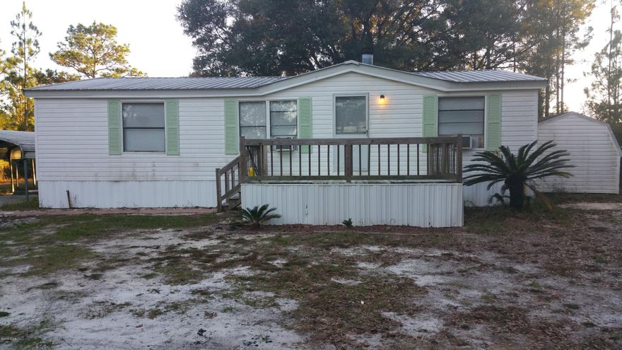 Total privacy!  This is an extremely rare opportunity: live in Lynn Haven close to the schools and stores but have extreme privacy.  Almost an acre

Drive to the end of the nice paved street and the driveway to this property exits at the end of a culdesac of nice houses and turns through the woods.  The mobile is a fixer upper which can be your residence until your home is built or continue to use it as a rental. There is a carport, a 10 x 12 bldg, and a 16 x 20 aluminum bldg built in 2006. There are other storage buildings on the property. It would be highly unusual to find another one with this much privacy.