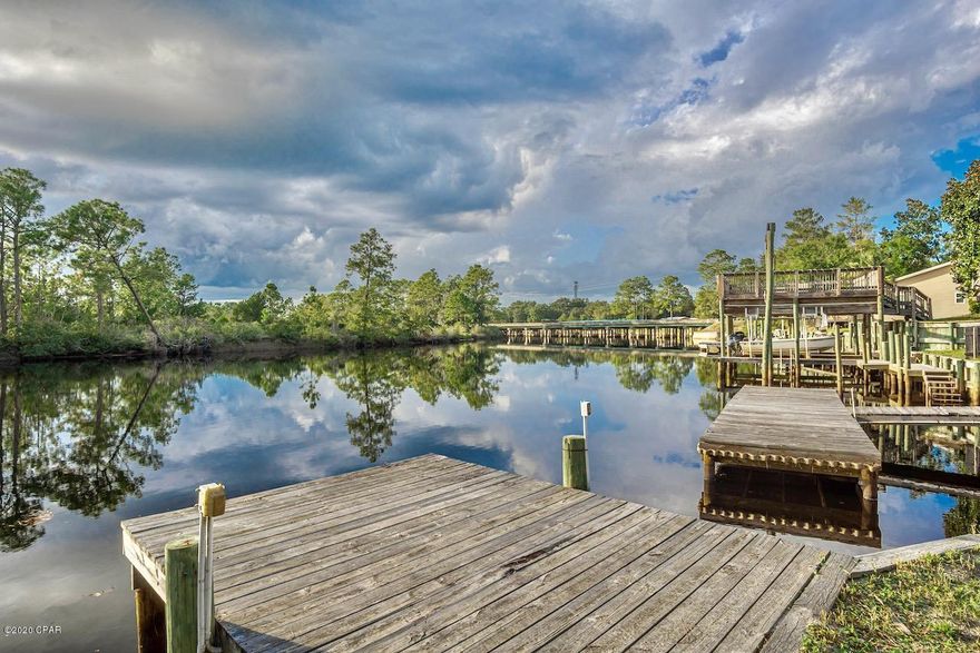 Coffee breaks are so enjoyable in this charming Florida cottage.  Watch the boats go by as the sun glistens on the water!. This beautiful waterway goes into West Bay and out to the Gulf of Mexico!  Keep byour boats at your very own docks with  115 feet of waterfront on the most gorgeous creek, located a short drive to Pier Park Shopping and activities, Frank Brown Park and Panama City Beach! The cottage has a wraparound deck that leads to a 14 x 24 screened in porch.  

There is also a bridge that leads to their 24 x24 screened in pavilion perfect for outdoor cookouts. This creek is rare because it is hard to find

waterfront with adequate depth to keep a boat at your dock, and the creek offers some safe harbor from the wind. Not many fish camps like this, act fast!

Please verify all info All measurements are estimated, please verify.  This waterway is a creek, there was not an option in this program for waterfront creek
that has access to the gulf, so waterfront option shows river.