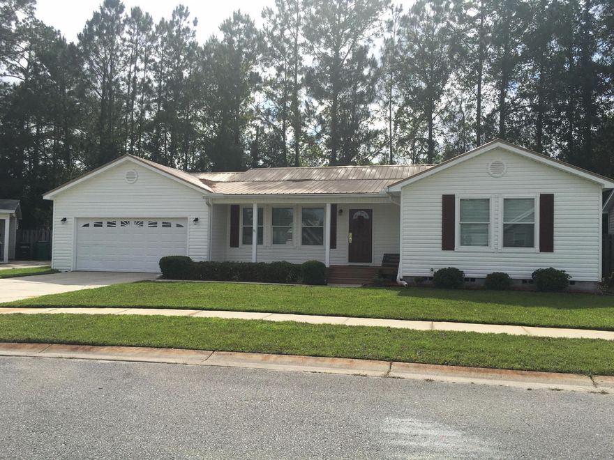 Location to Tyndall Air Force Base is 10 minutes away!  This adorable contemporary home has a newer Metal roof, BRAND NEW ENGINEERED REAL WOOD FLOORS IN LIVING ROOM & KITCHEN, carpeted bedrooms, and a large fenced yard.  Huge 2 car garage with a workbench and storage galore! Open floor plan, with crown moldings, rounded bull nose corners, raised six panel architectural interior doors, brushed alloy light fixtures, and ceiling fans accent this well built home.  The guests rooms have walk in closets, the master has its own full bath with double vanity sinks.  Please check measurements if important.